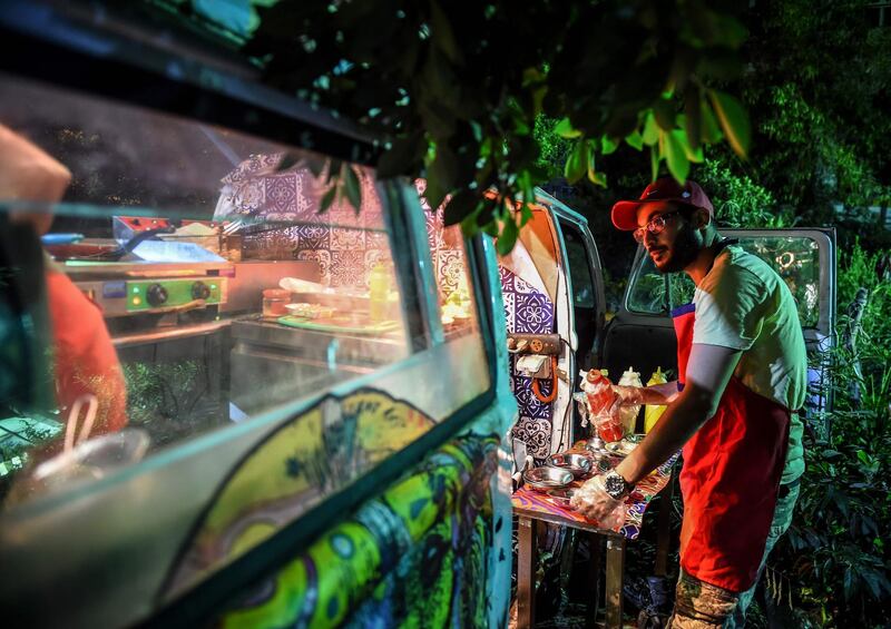 Kareem Mahmoud, a 32-year-old Egyptian, prepares a dish of fava beans for customers from a novelty food cart in the capital Cairo's southern suburb of Maadi. AFP