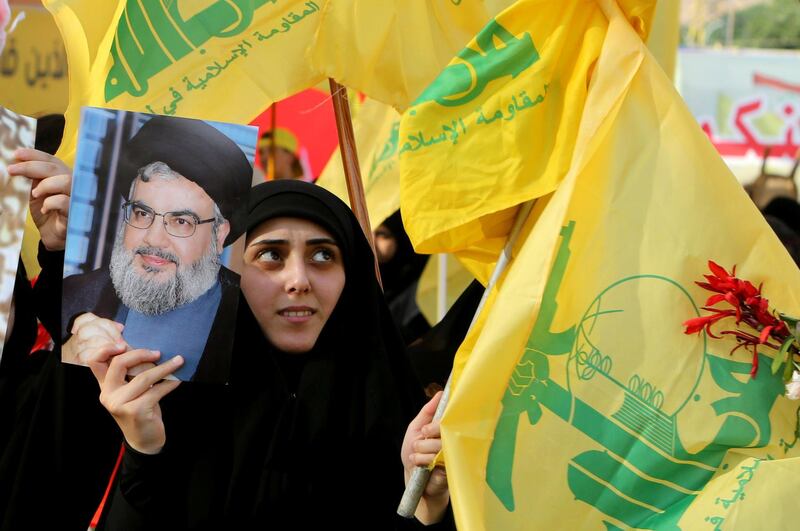 A supporter of Lebanon's Hezbollah leader Sayyed Hassan Nasrallah holds a picture of him during a rally marking the anniversary of the defeat of militants near the Lebanese-Syrian border, in al-Ain village, Lebanon August 25, 2019. REUTERS/Aziz Taher       NO RESALES. NO ARCHIVES.