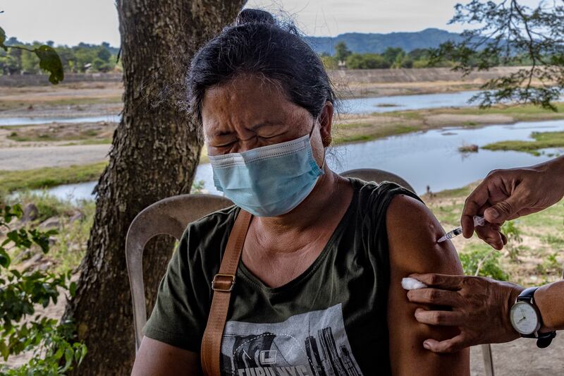 A resident receives a dose of Pfizer-BioNTech Covid-19 vaccine at a rural village in Aringay, La Union province, Philippines. The archipelago is rushing to vaccinate its population as it considers making vaccination mandatory to deal with the looming threat of the Omicron variant of the coronavirus. The country, which has just approved booster shots for its adult population, launched a three-day national vaccination holiday on November 29 to December 1 with the goal of vaccinating at least nine million additional people. Getty Images