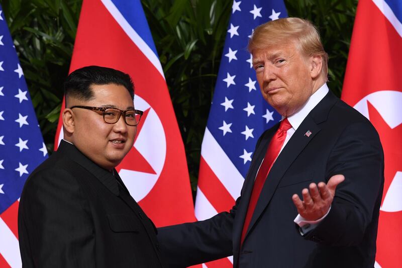 (FILES) In this file photo taken on June 12, 2018 US President Donald Trump (R) meets with North Korea's leader Kim Jong Un (L) at the start of their US-North Korea summit, at the Capella Hotel on Sentosa Island in Singapore. - Donald Trump rose to power proposing a simple solution to the United States' deepest problems: himself. "I alone can fix it," the property tycoon pronounced in 2016 on the day he accepted his Republican Party's nomination to seek the presidency. Four years later, at the end of a first term that convulsed the world, the 74-year-old billionaire showman is seeking reelection. Yet having come in vowing to end what he called "American carnage," he instead presides over turmoil, accused by many of breaking, not fixing, a country in greater disarray than at any point since the 1970s. (Photo by SAUL LOEB / AFP)