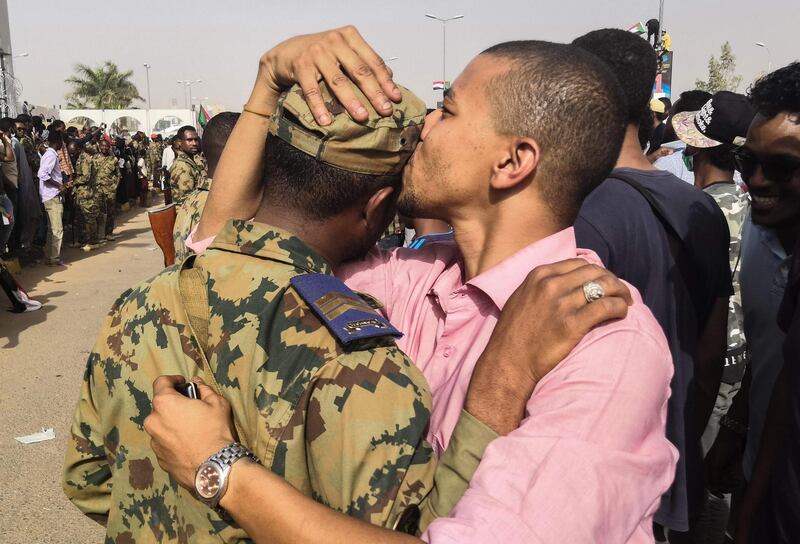 A Sudanese anti-regime protester kisses a soldier on the head during protests on April 11, 2019 in the area around the army headquarters in Sudan's capital Khartoum.  AFP