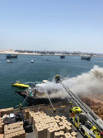 The dhow is covered in smoke as crews bring the fire under control.