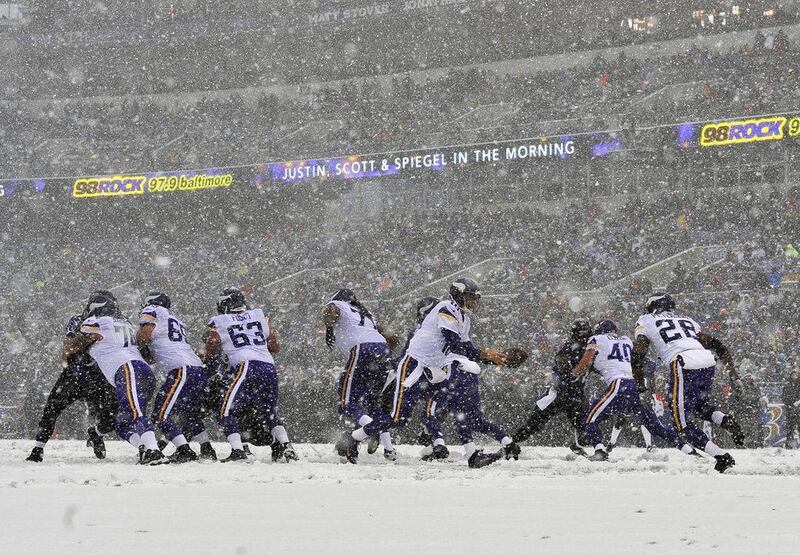 Minnesota quarterback Matt Cassel hands off to Adrian Peterson in the snow in Baltimore. Gail Burton / AP