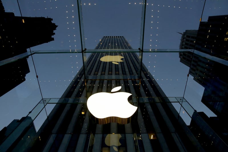 The Apple logo is illuminated in the entrance to the Fifth Avenue Apple store, in New York. Apple will replace AT&T in the Dow Jones industrial average after the close of trading on Wednesday, March 18, the manager of the index announced. AP Photo