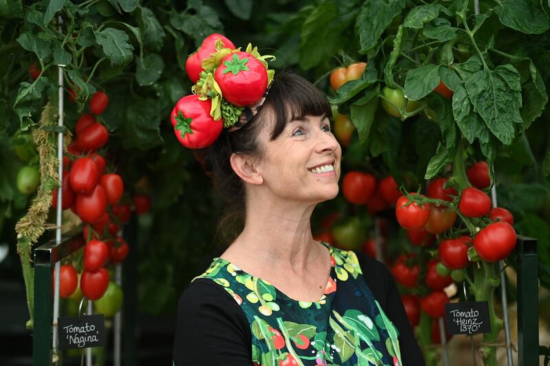 A woman wearing a tomato-themed hat poses for a photo. AFP