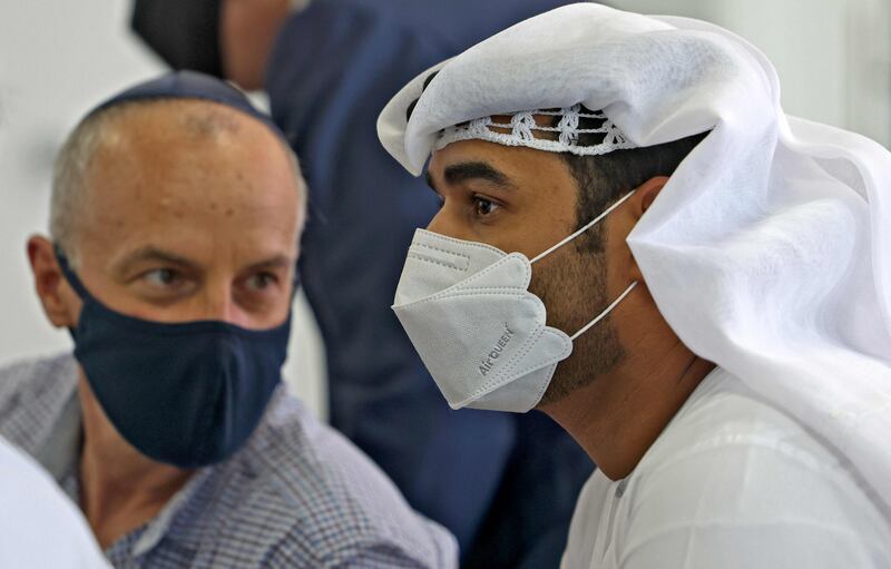 A Jewish man and Emirati listen as Mr Lapid talks about ties between Israel and the Emirates. Karim Sahib / AFP