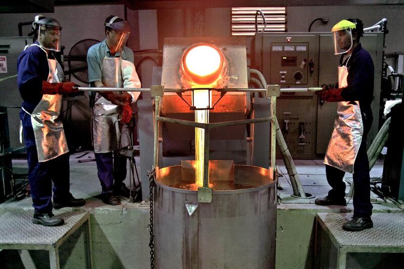 Strings of melted gold from a 350 kg gold bar drip into water during the smelting process at the Emirates Gold company in Dubai. Kamran Jebreili / AP Photo