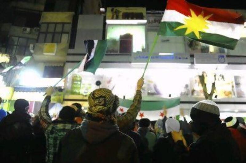 Demonstrators and wave a Kurd flag and pre-Baath Party Syrian flags during a protest against Syria's President Bashar Al Assad in Qudsaya, near Damascus.