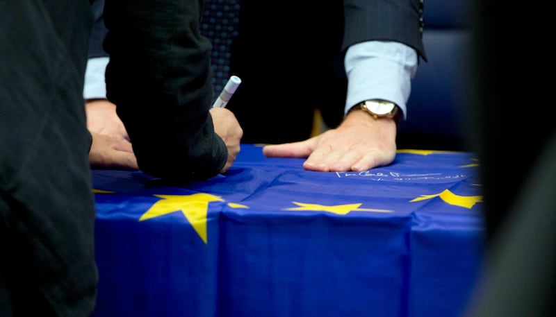 Eurogroup finance ministers sign an EU flag during a round table meeting of eurogroup finance ministers in Luxembourg, Monday, Oct. 9, 2017. Wolfgang Schaeuble, the long-time German finance minister, is attending his final meeting of his peers in the 19-country eurozone on Monday. (AP Photo/Virginia Mayo)