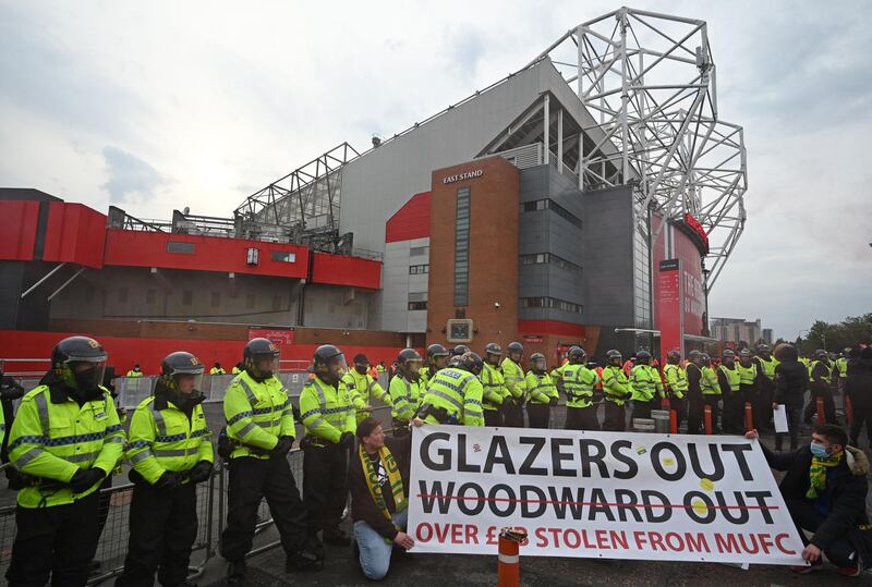 Police officers stand on duty as fans protest against United's owners. AFP