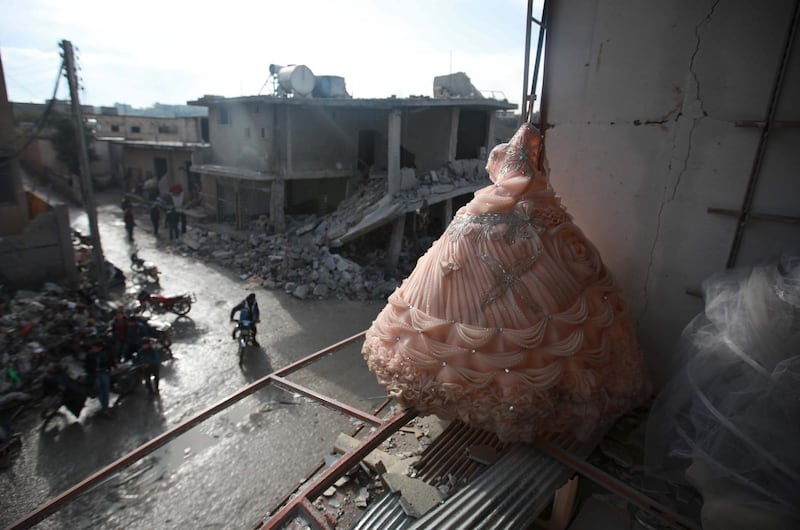 A wedding dress is seen in the destroyed window of a bridal shop in a damaged building in Balyun in Syria's northwestern Idlib province the day after a reported Russian airstrike on a market in the village. AFP