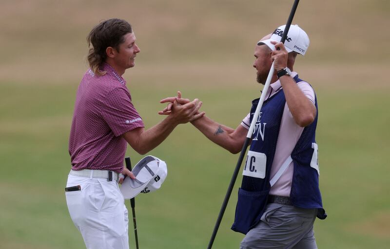 Australia's Cameron Smith celebrates with his caddie after making a birdie on the 18th. Reuters