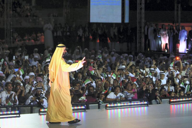 Ruler of Dubai Sheikh Mohammed Bin Rashid al-Maktoum salutes the crowd as he takes part in celebrations near Dubai's Burj Khalifa, the world's tallest tower, on December 1, 2013, marking the United Arab Emirates national day and the victory for Dubai to host the 2020 World Expo. A jubilant Dubai hopes that hosting the world's five-yearly trade fair in 2020 will draw new investment to an economy still recovering from a debt crisis that required a bailout by Abu Dhabi PHOTO/MARWAN NAAMANI (Photo by MARWAN NAAMANI / AFP)