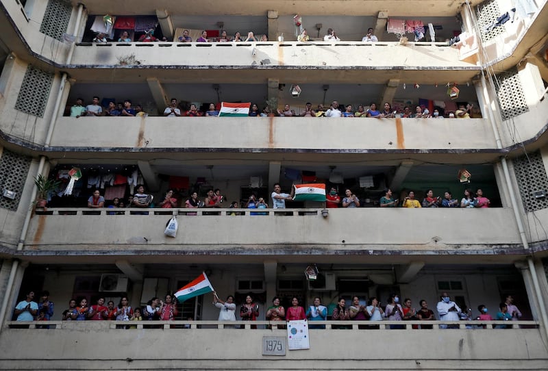 People clap and bang utensils from their balconies to cheer for emergency personnel and sanitation workers who are on the frontlines in the fight against coronavirus, in Mumbai, India. Reuters