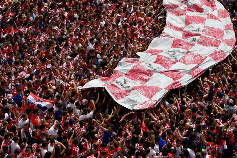 People hold a giant banner with the national colours of the country during a 'heroes' welcome' for Croatian national football team. Andrej Isakovic / AFP