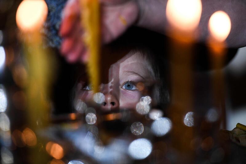 A Russian Orthodox child looks at candles as he attends a Christmas service in Christ the Savior cathedral in Moscow.  AFP