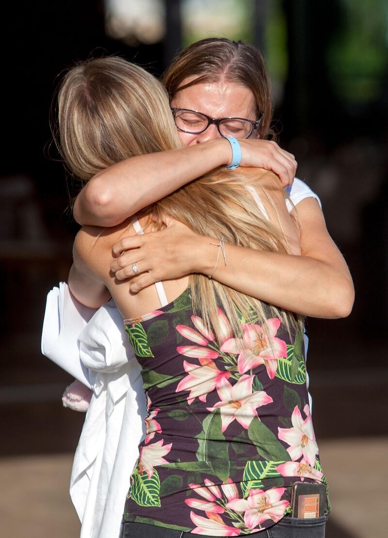 Guests of the Acapulco hotel in Kyrenia (Girne) in the self-proclaimed Turkish Republic of Northern Cyprus (TRNC) north of the divided Cypriot capital Nicosia, embrace after the building was damaged when a military depot exploded nearby, on September 12, 2019. Multiple explosions at a Turkish military base in northern Cyprus damaged a hotel in a neighbouring holiday resort early Thursday, prompting the evacuation of terrified tourists, officials said. / AFP / Birol BEBEK
