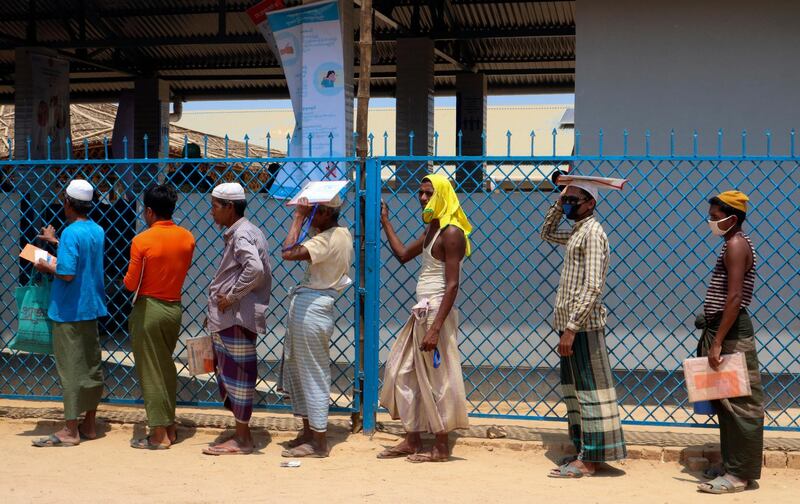 Rohingya refugees stand in line to collect food aid at the Kutupalong refugee camp in Cox's Bazar, Bangladesh. AP