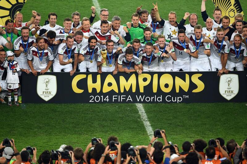 German squad members pose with the World Cup trophy, their first since 1990. Christophe Simon / AFP