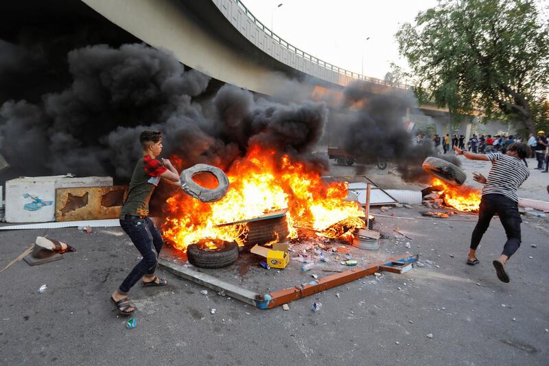 Demonstrators burn tires as they block the road in Baghdad. Reuters