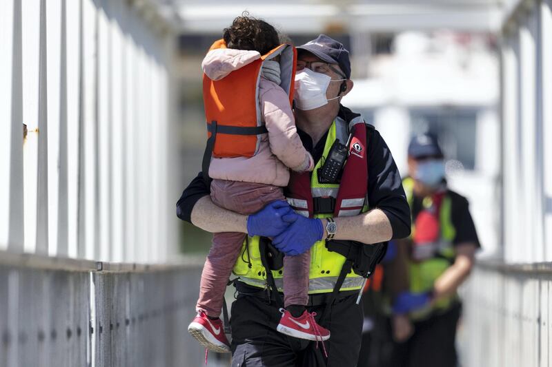 DOVER, ENGLAND - JUNE 09: Border Force officials hold a young girl that arrived with other migrants after being picked up in a dinghy in the English Channel on June 09, 2021 in Dover, England. More than 500 migrants arrived in the final week of May, according to the UK Home Office, adding that 3,600 people had been stopped from crossing the channel by French authorities. (Photo by Dan Kitwood/Getty Images) (Photo by Dan Kitwood/Getty Images)