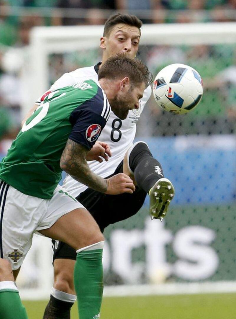 Northern Ireland's Oliver Norwood, left, and Germany's Mesut Ozil vie for the ball during the Euro 2016 Group C soccer match between Northern Ireland and Germany at the Parc des Princes stadium in Paris, France, Tuesday, June 21, 2016. (AP Photo/Michael Probst)