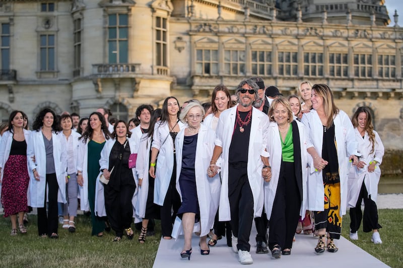 Designer Pier Paolo Piccioli, centre, accepts applause as he leads his team after the conclusion of the Valentino Haute Couture Fall/winter 2023-2024 fashion collection presented in Chantilly, north of Paris, Wednesday, July 5, 2023.  (AP Photo / Christophe Ena)