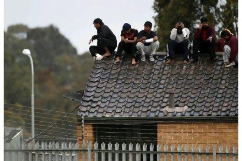 Asylum seekers threaten to jump off the roof of the Villawood immigration detention centre in Sydney during a protest in September.