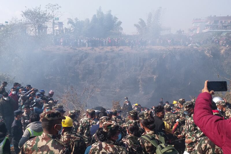 Crowds gather as rescue teams work to retrieve bodies at the crash site of an aircraft carrying 72 people in Pokhara in western Nepal. Reuters