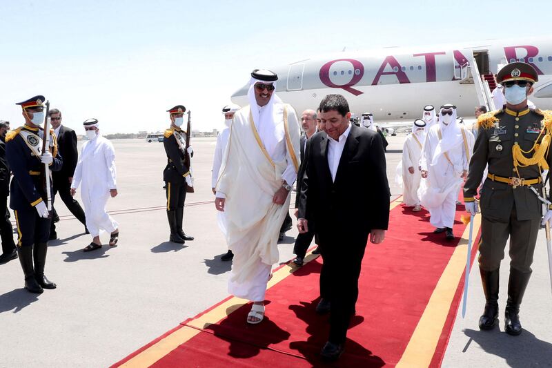 Mr Mokhber greets Sheikh Tamim upon his arrival at Mehrabad Airport. Reuters