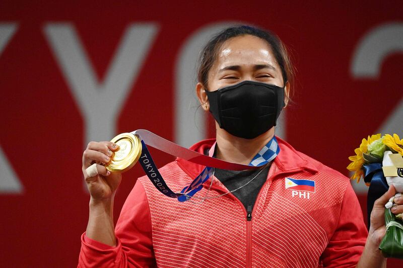 Gold medalist Hidilyn Diaz stands on the podium for the victory ceremony of the women's 55kg weightlifting competition.