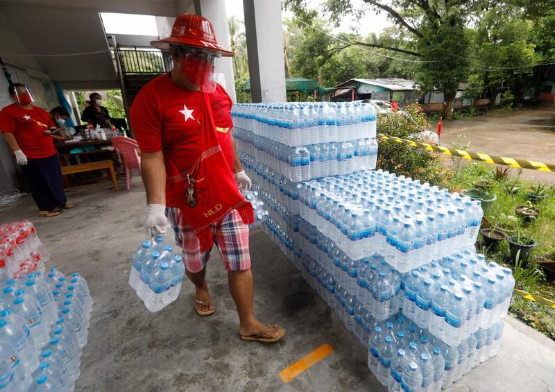A supporter of the National League for Democracy (NLD) party donates drinking water at a quarantine facility center in Yangon, Myanmar. Yangon, Myanmar's biggest city, is being locked down with a stay-at-home order after the surge of new cases of COVID-19 reached record high and which marked the region as the center of Myanmar's outbreak of COVID-19 disease. EPA