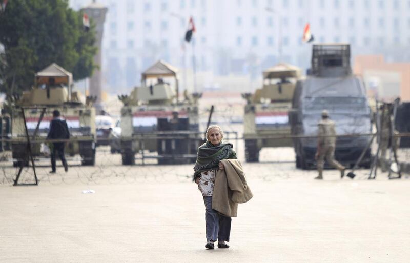A woman crosses Tahrir Square’s entrance, which is blocked by armoured vehicles and barbed wire, on the fourth anniversary of the 2011 uprising that toppled autocrat Hosni Mubarak in Cairo, January 25, 2015. Mohamed Abd El Ghany / Reuters