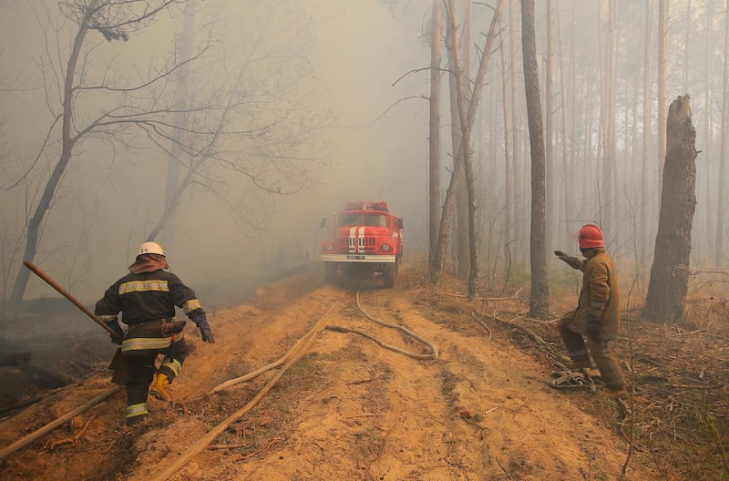 Ukrainian firemen fight with forest fire which burns near the village of Ragovka, close to the exclusion zone. EPA