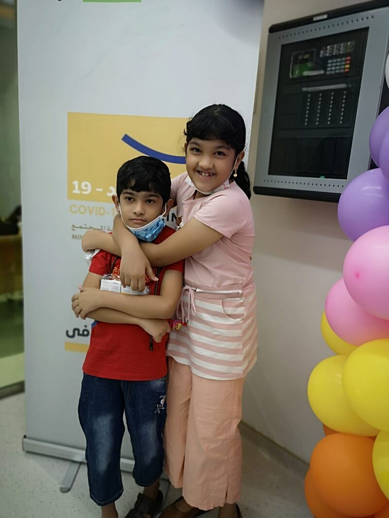 Sidrathul Munthaha, 9, from Bangladesh, with her younger brother after they received their first shot of the Sinopharm Covid-19 vaccine.