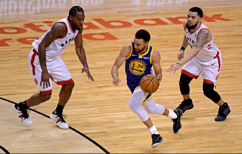 Golden State Warriors guard Stephen Curry, centre, drives to the basket against Toronto Raptors forward Kawhi Leonard (2) and guard Fred VanVleet (23). USA Today