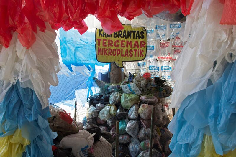 A placard reads 'Brantas river polluted with microplastic' among plastic bags displayed at the plastic museum built by Indonesia's environmental activist group Ecoton.