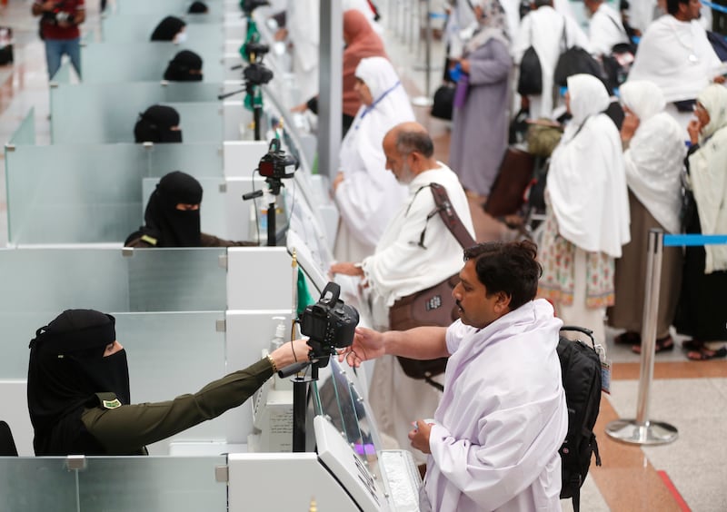 Saudi female officers from  the national security forces, register and check pilgrims at the Hajj Terminal at Jiddah airport, Saudi Arabia, Saturday, Aug. 3, 2019.  The annual Islamic pilgrimage draws millions of visitors each year, making it the largest yearly gathering of people in the world.  (AP Photo/Amr Nabil)