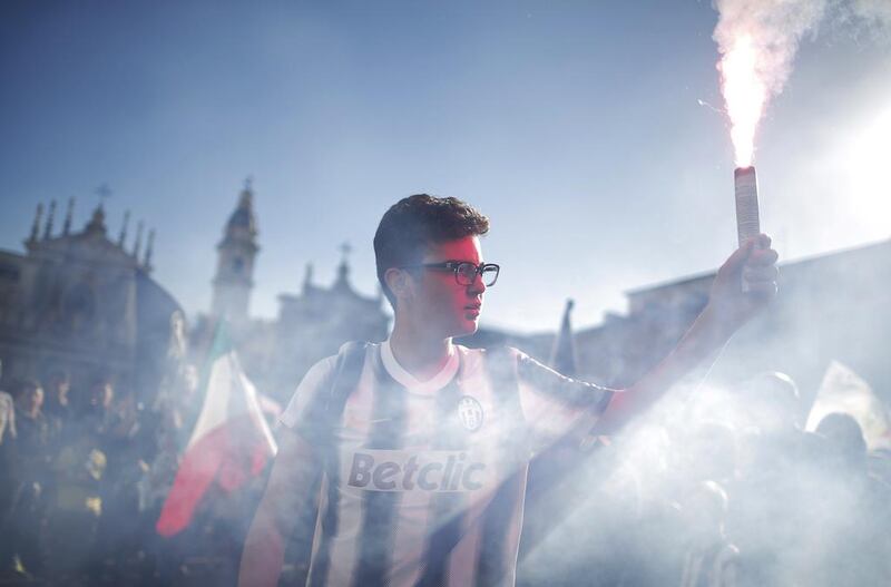 A Juventus supporter holds a flare as he celebrates the club's Serie A title. Marco Bertorello / AFP / May 4, 2014