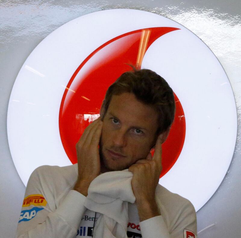 McLaren Formula One driver Jenson Button of Britain covers his ears inside his garage during the third practice session of the Abu Dhabi F1 Grand Prix at the Yas Marina circuit on Yas Island November 3, 2012.  REUTERS/Suhaib Salem (UNITED ARAB EMIRATES  - Tags: SPORT MOTORSPORT F1)   *** Local Caption ***  PSQ453_MOTOR-RACING_1103_11.JPG