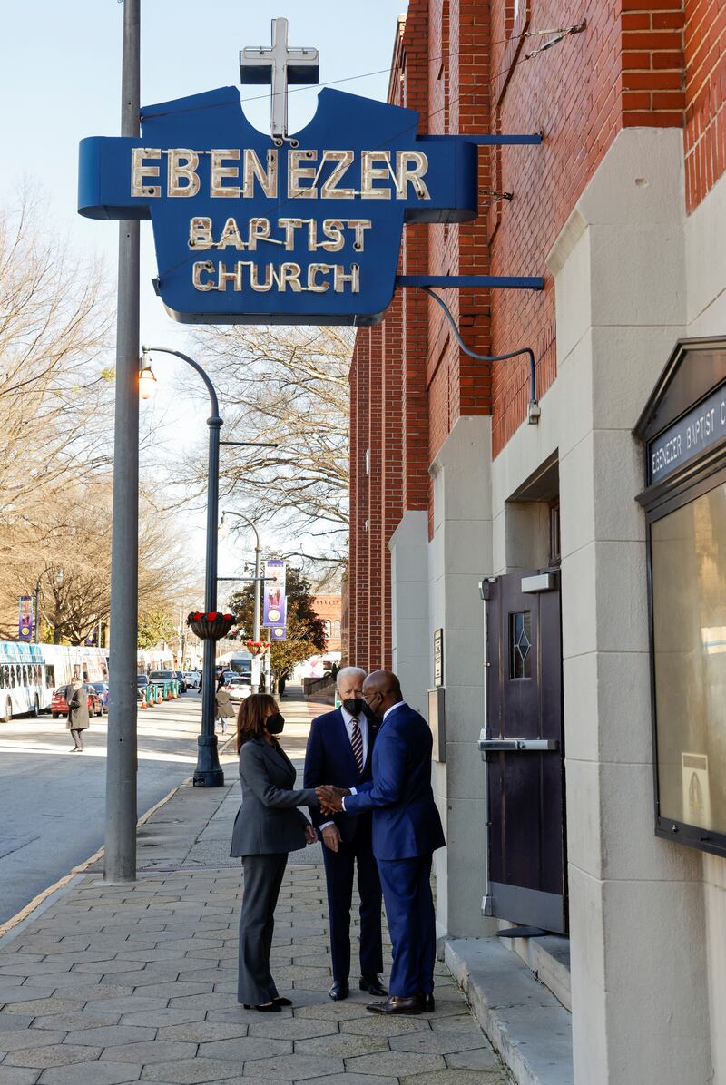 US President Joe Biden and Vice President Kamala Harris talk to Mr Warnock at the entry to Ebenezer Baptist Church in Atlanta, Georgia, where he serves as pastor. Reuters