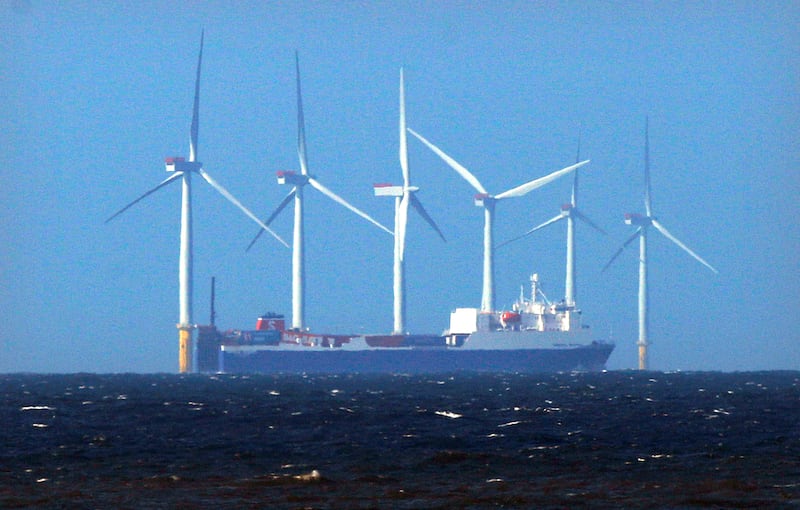 A ship sails past the Barrow offshore 90 megawatt wind farm, developed by British and Danish energy groups Centrica and DONG Energy, off the coast of Cumbria, England April 12, 2011. Offshore wind farm construction costs in Britain need to drop by around 30 percent over the next decade if the sector is to develop and help the country meet its green energy targets, British offshore wind farm developer SeaEnergy Renewables said April 12, 2011. Picture taken April 12, 2011.  REUTERS/David Moir (BRITAIN - Tags - Tags: ENERGY ENVIRONMENT BUSINESS) - LM1E74D0TZF01