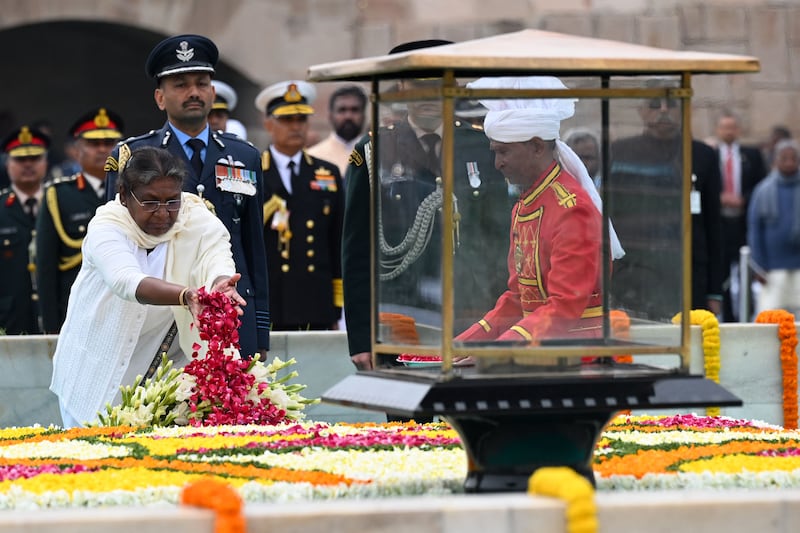 Indian President Droupadi Murmu scatters rose petals at the memorial. AFP