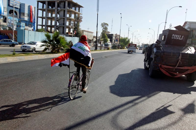 A man rides a bicycle with Iraqi flag in north of Kirkuk, Iraq October 19, 2017. Picture taken October 19, 2017. REUTERS/Ako Rasheed