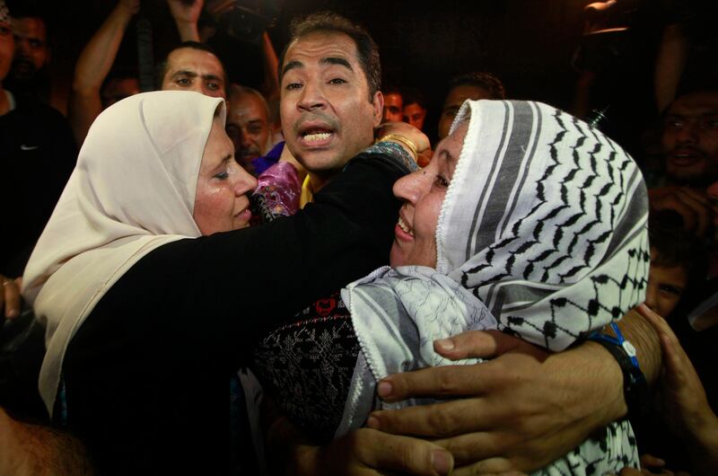 A freed Palestinian prisoner is hugged by his mother (R) upon his arrival near Erez Crossing, between Israel and northern Gaza Strip, early August 14, 2013. Israel freed 26 Palestinian prisoners on Wednesday to keep U.S.-sponsored peacemaking on course for a second round of talks, but diplomacy remained dogged by Israeli plans for more Jewish homes on land the Palestinians claim for a future state. REUTERS/Mohammed Salem (GAZA - Tags: POLITICS) *** Local Caption ***  GAZ20_PALESTINIANS-_0813_11.JPG