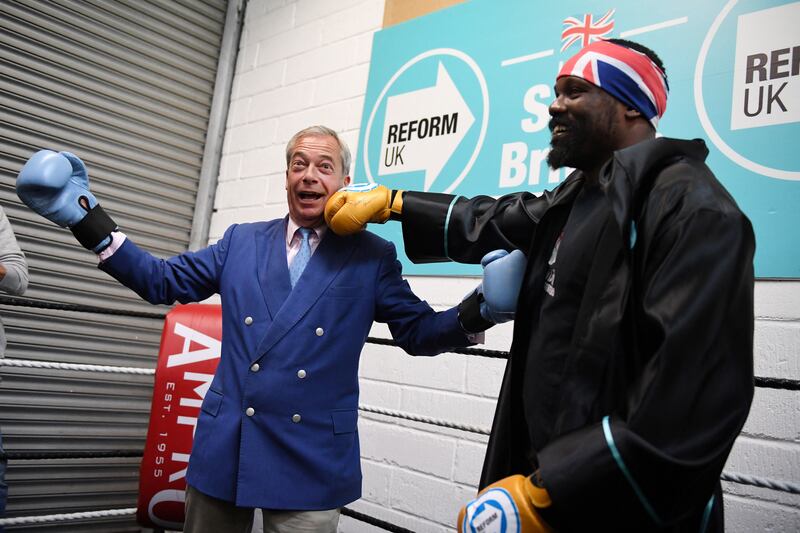 Nigel Farage, leader of the far-right Reform UK Party, with heavyweight boxer Derek Chisora during a campaign visit to Clacton-on-Sea in eastern England. Reuters