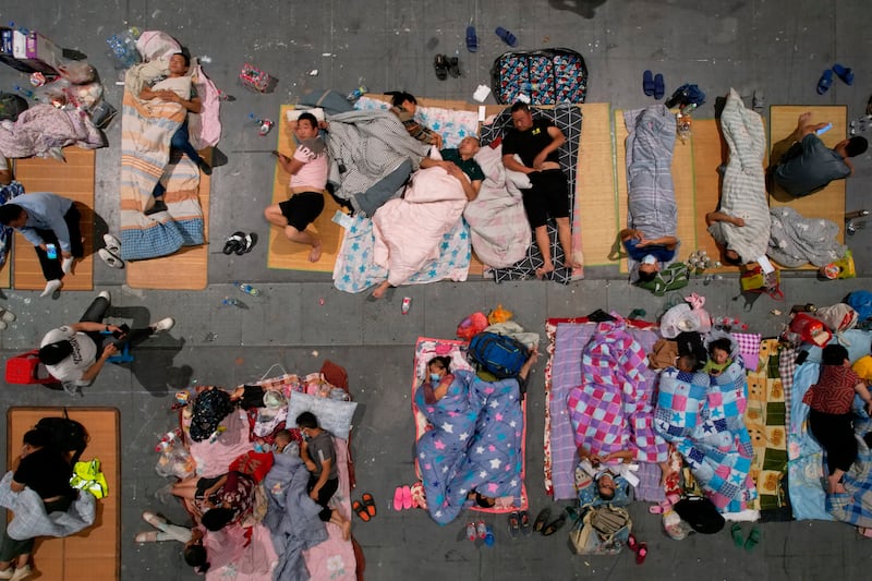 Migrant workers and their family rest in an exhibition hall after being moved from their workplaces in Hangzhou in eastern China's Zhejiang province.
