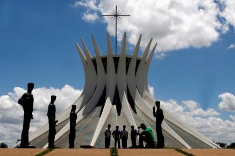 Tourists take pictures in front of the Metropolitan Cathedral designed by architect Oscar Niemeyer in Brasilia, in this December 12, 2007 file photo. Niemeyer, a towering patriarch of modern architecture who shaped the look of modern Brazil and whose inventive, curved designs left their mark on cities worldwide, died late on December 5, 2012. He was 104. Niemeyer had been battling kidney ailments and pneumonia for nearly a month in a Rio de Janeiro hospital. His death was confirmed by a hospital spokesperson. REUTERS/Jamil Bittar/Files (BRAZIL - Tags: OBITUARY SOCIETY) *** Local Caption ***  BRA106_BRAZIL-NIEME_1206_11.JPG