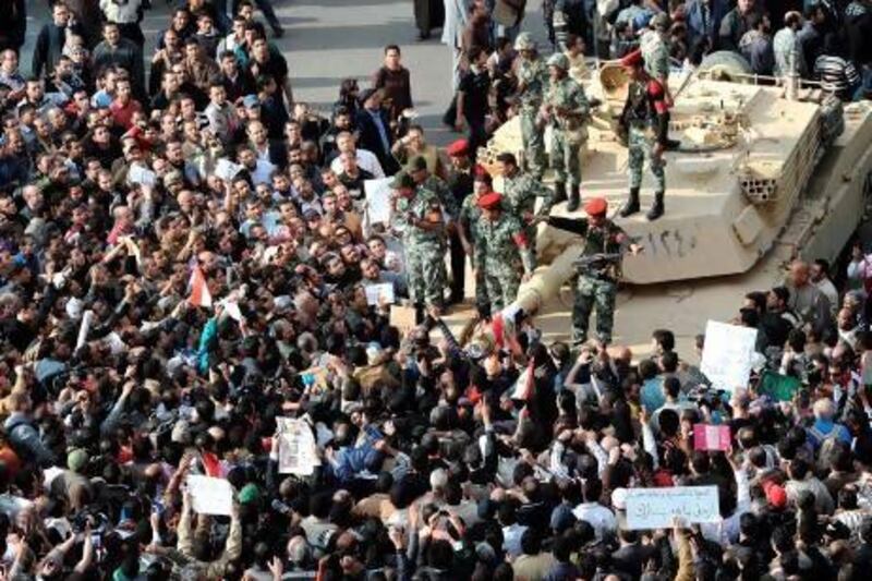 Egyptian soldiers address protesters as they gather around an army tank stationed at Tahrir Square in Cairo on January 30, 2011 on the sixth day of angry revolt against Hosni Mubarak's regime amid increasing lawlessness, a rising death toll and a spate of jail breaks.