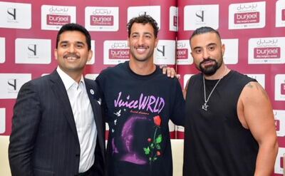 Daniel Ricciardo sports his new look alongside Dr Shamsheer Vayalil, chairman and managing director of VPS Healthcare and Kris Fade, Virgin Radio Dubai talk show host